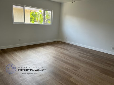the living room of a house with wooden floors and a window